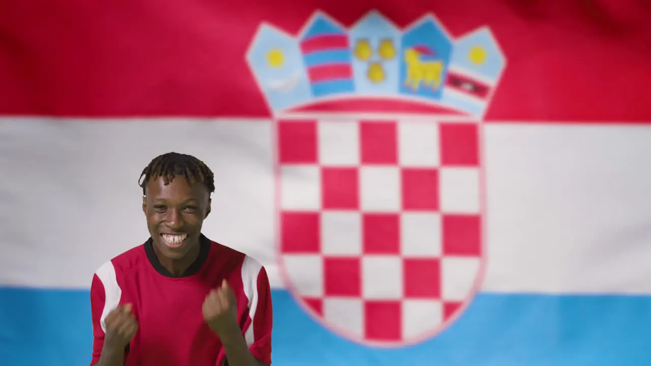 Young Footballer Celebrating to Camera In Front of Croatia Flag 01