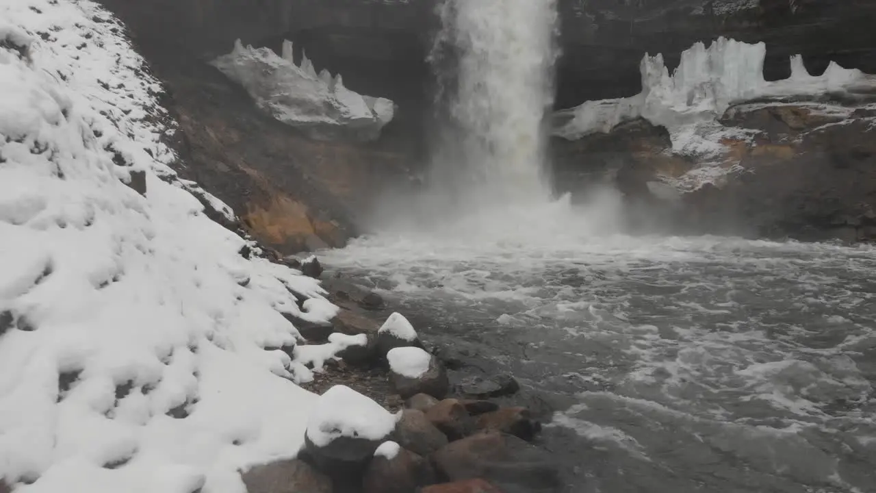 Showing a waterfall and river from a low angle during a cloudy winter day