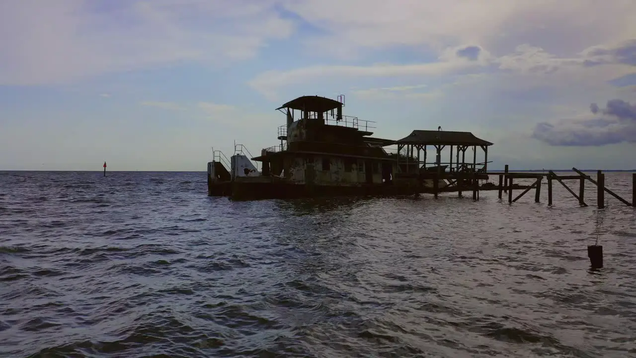 Semi sunken push boat docked in a river on a cloudy day