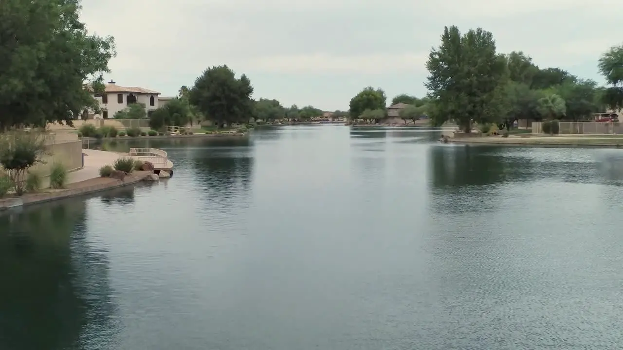 Aerial drone shot flying out over a community lake on a cloudy day