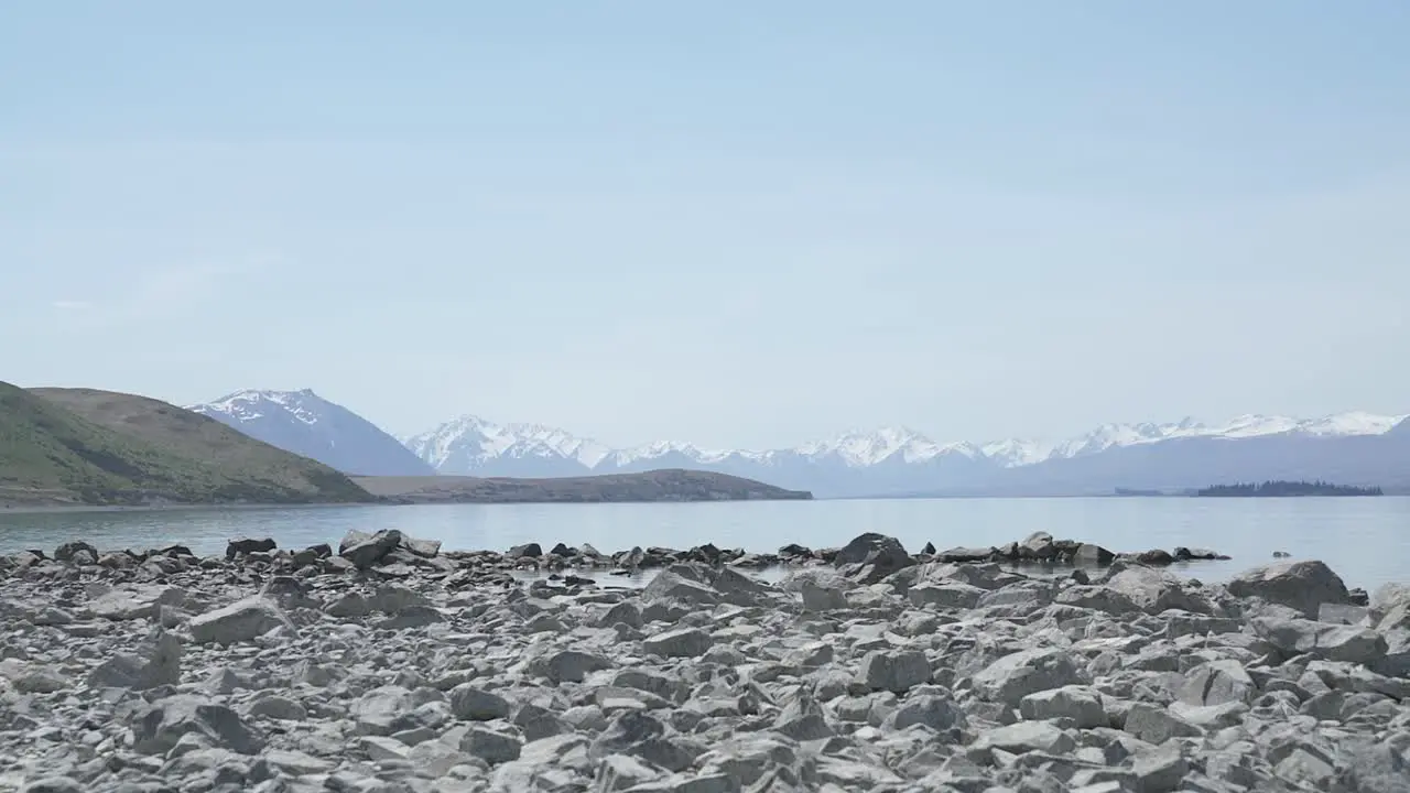 panning view of lake tekapo from right to left the rocks on the beach