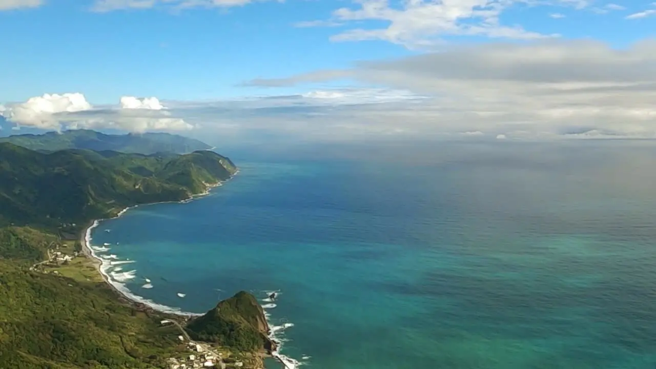 Pacific ocean meeting the shores of island of Taiwan on slightly cloudy day