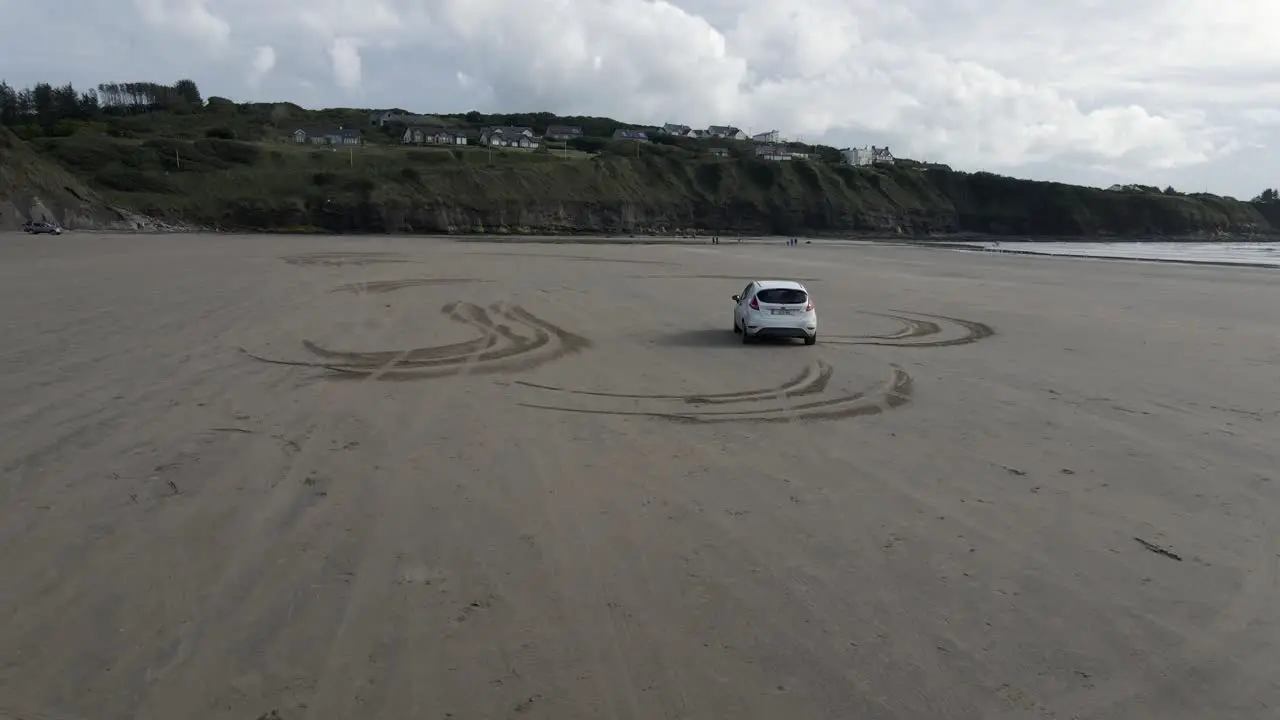 White car driving on a beach in Ireland