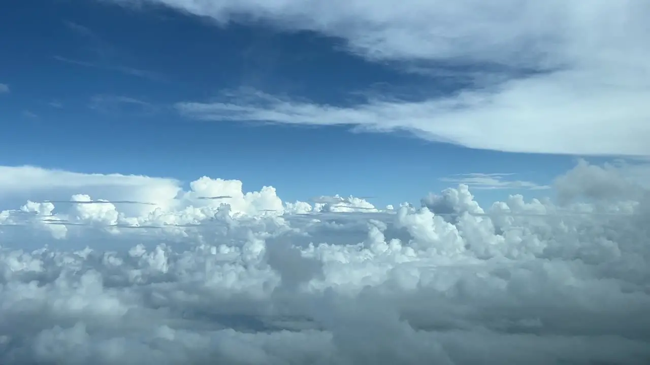 Aerial view from a jet cockpit while flying over clouds