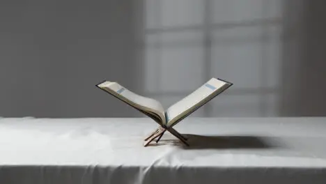 A Handheld Wide Shot of the Quran On Covered Surface