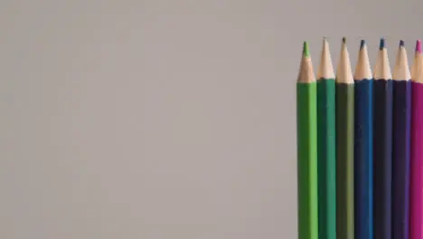 Studio Shot Of Rotating Line Of Multi-Coloured Pencils Against Grey Background 2