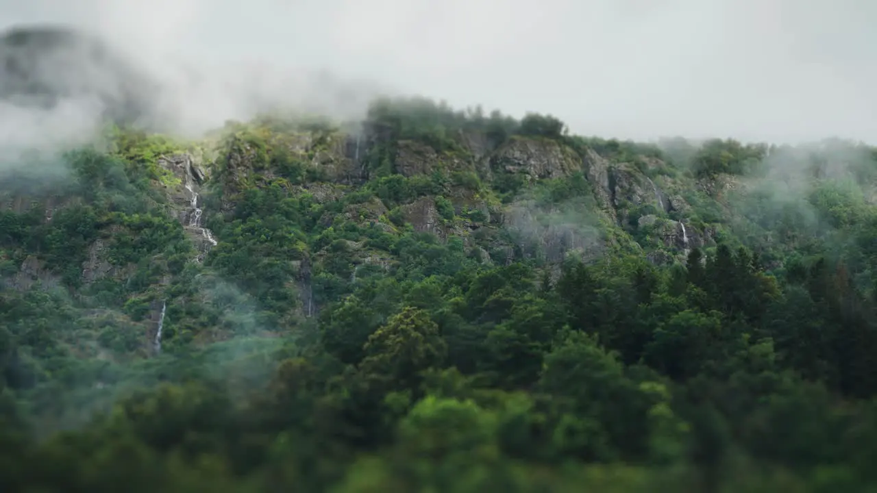 Fog hangs above the forest-covered cliffs and waterfalls