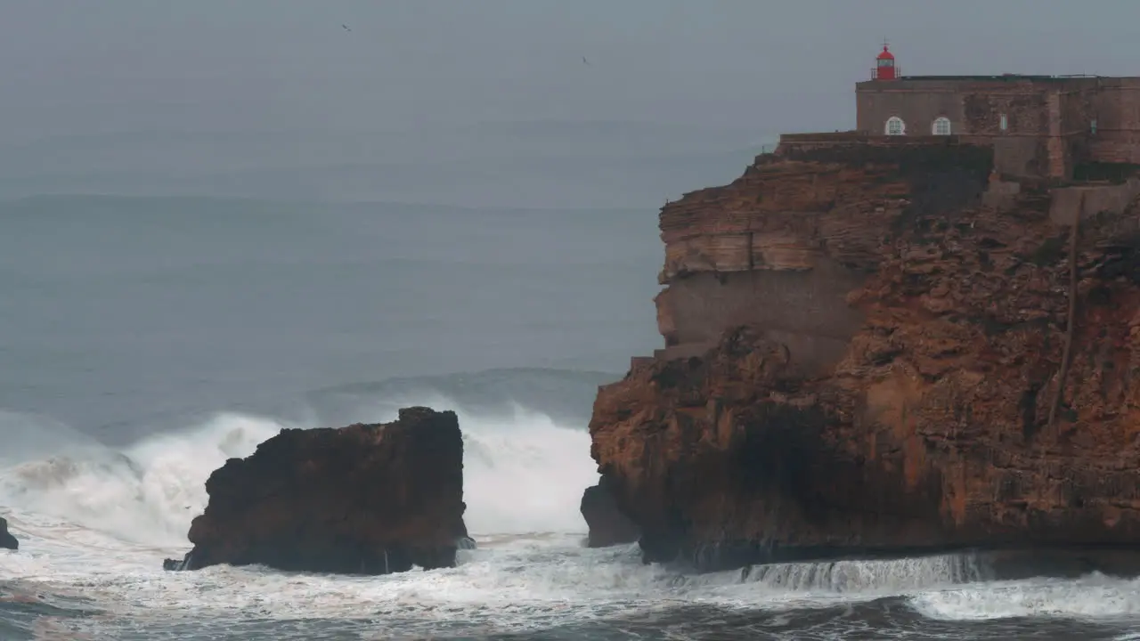 Nazare lighthouse and powerful ocean waves Portugal