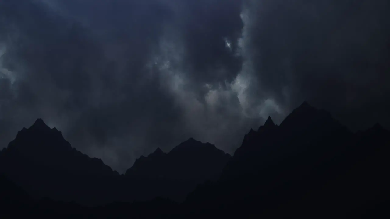 Silhouette mountains on the background of dark clouds and lightning strike