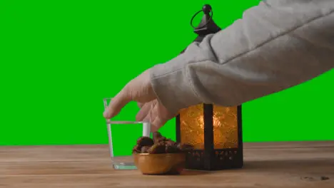 A Tracking Shot of Lantern Water and Dates In Front of a Green Screen