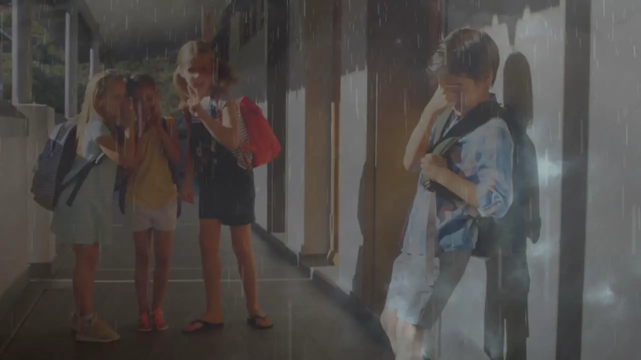 Composite video of rainfall and thunderstorms against group of students bullying a boy at school