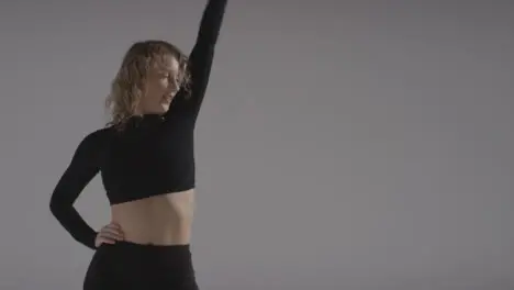 Studio Shot Of Young Woman Doing Dance Practise Against Grey Background 2