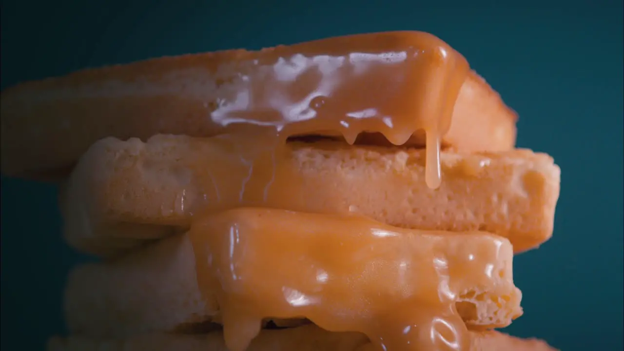 Pouring caramel on waffles close up