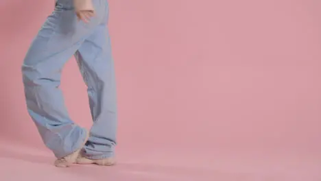 Close Up On Legs And Feet Of Woman Having Fun Dancing Against Pink Studio Background 2