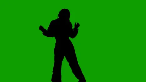 Studio Silhouette Of Woman Dancing Against Green Background