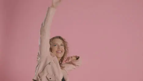 Studio Shot Of Young Woman Having Fun Dancing Against Pink Background 4