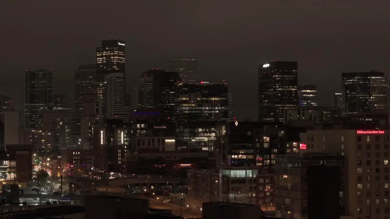 Long aerial zoom shot with reveal of Denver Colorado skyline at night