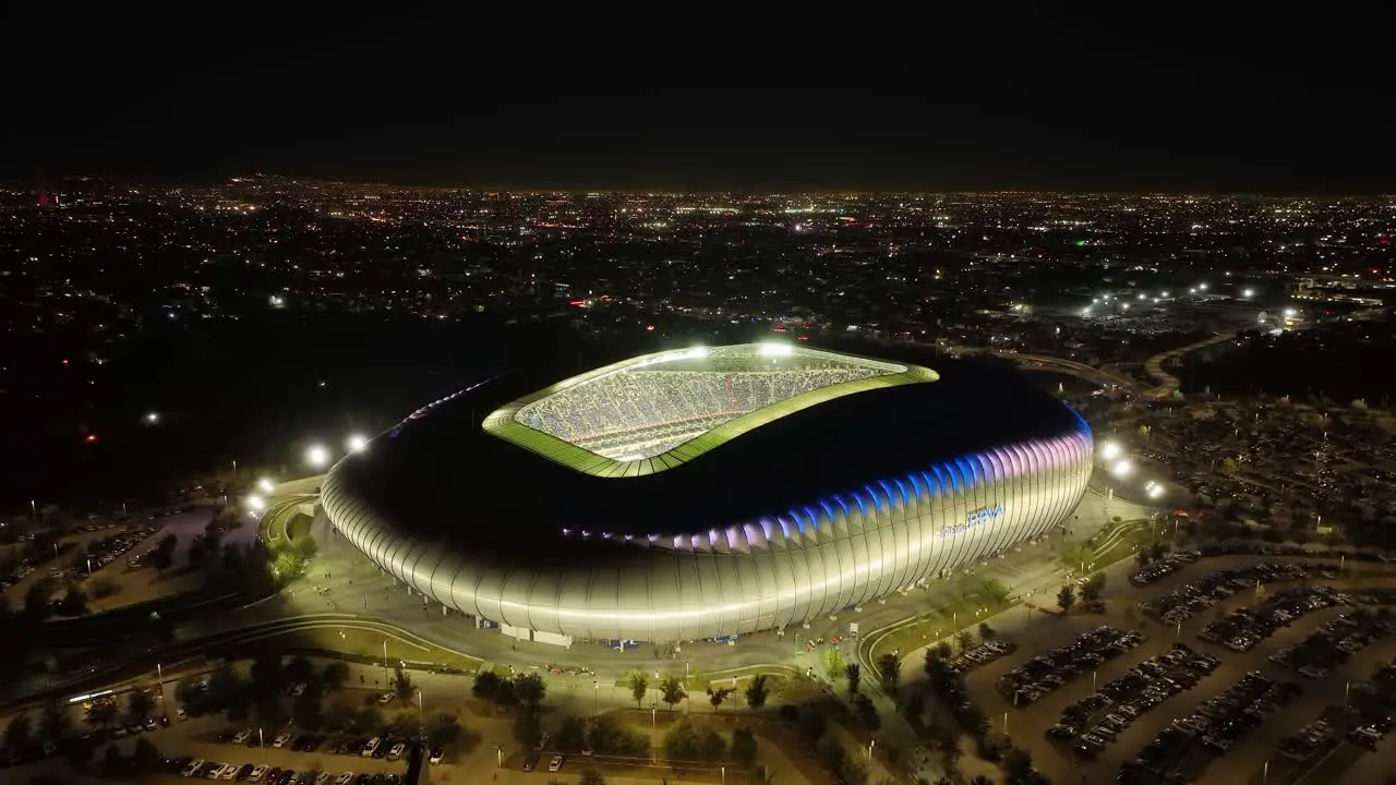 Aerial view rising away from the Estadio BBVA stadium night in Monterrey Mexico pull back drone shot