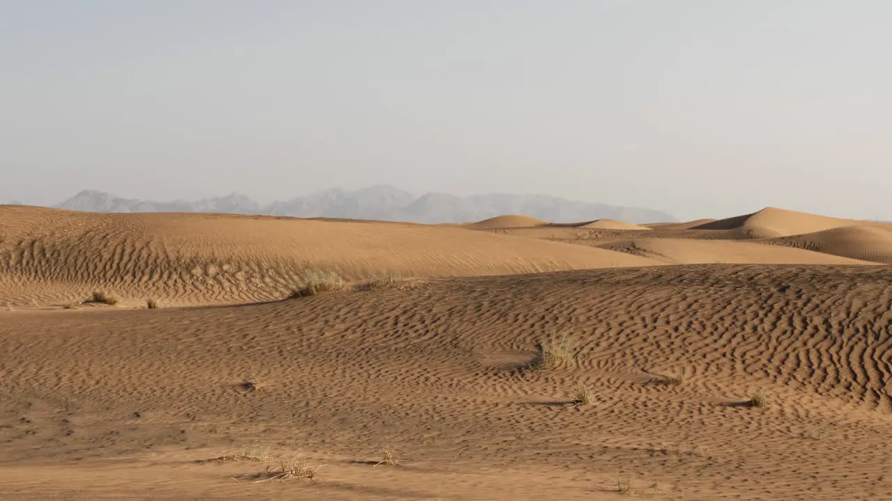 Middle eastern desert landscape near Dubai in the United Arab Emirates with sand dunes and distant mountains