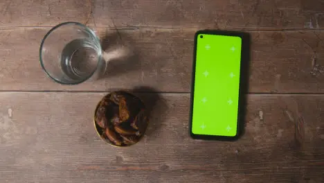 Handheld Shot of Dates and Water and Green Screen Phone