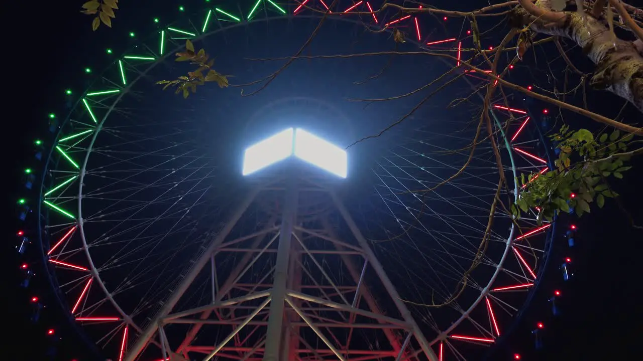 Time Lapse of a Big Wheel Going Around Illuminated With Colorful Changing Lights In the Night Time