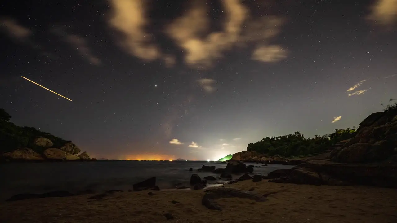 Glowing Cheung Chau harbour coastline airplane shooting stars lights night sky timelapse Hong Kong