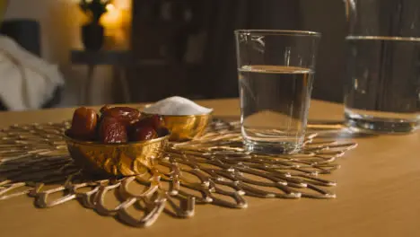 Bowl Of Dates With Glass Of Water On Table In Muslim Home Celebrating Eid 4