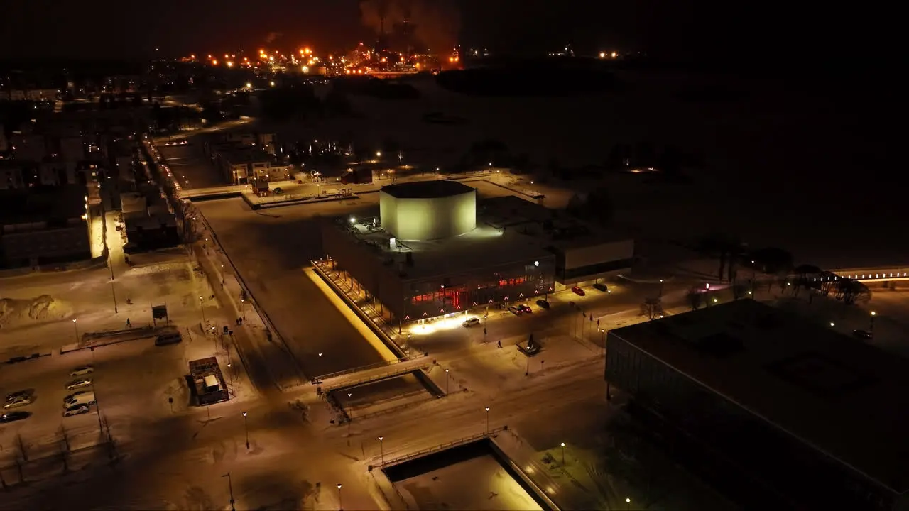 Flying around the illuminated Oulu Theatre winter night in Finland Aerial view