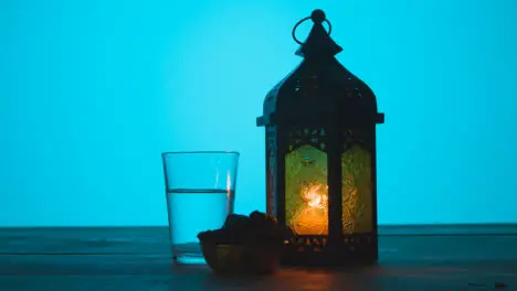 Tracking Shot of Lantern Water and Dates On a Table During Dusk 