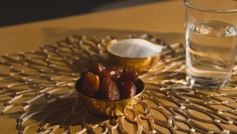 Bowl Of Dates With Glass Of Water On Table In Muslim Home Celebrating Eid 6