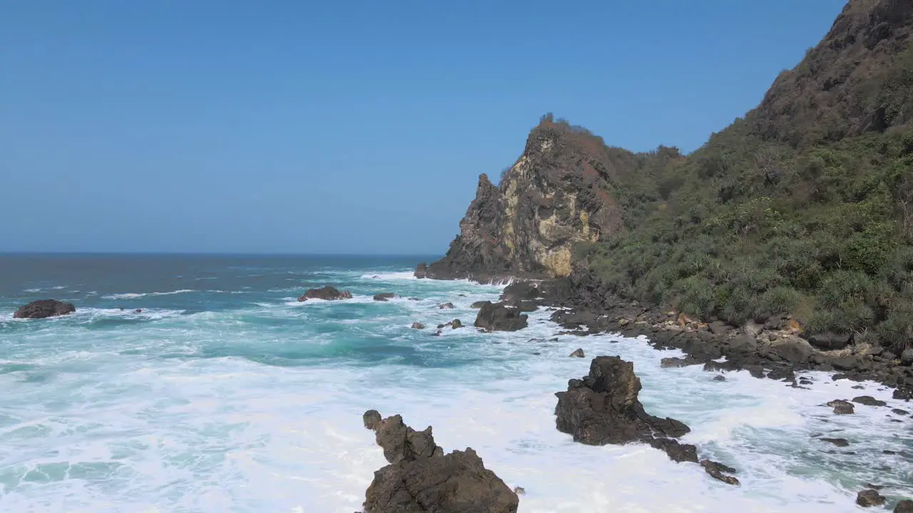 Shots flying backwards over the ocean surf on the rocky coast of Indonesia