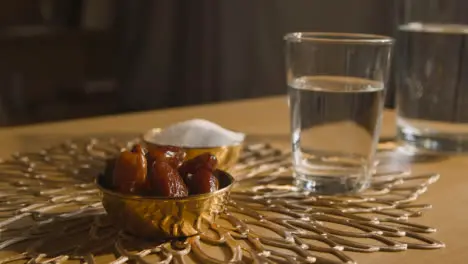 Bowl Of Dates With Glass Of Water On Table In Muslim Home Celebrating Eid 3