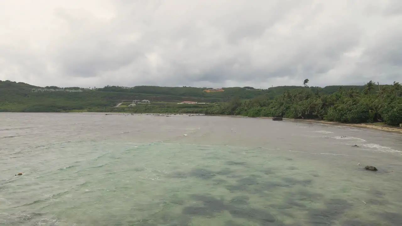 Panning over a tropical island bay during the beginning of a typhoon