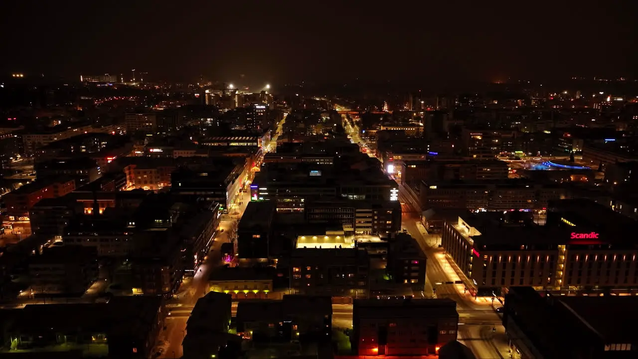 Aerial tracking shot of quiet night lit streets of Oulu city winter in Finland