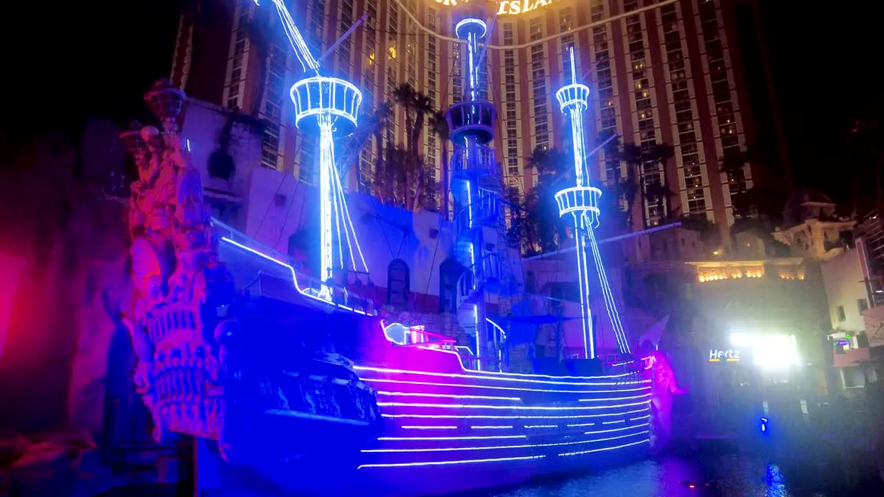 Dive into the vibrant neon glow of Treasure Island's iconic ship display captures the radiant blue and purple lights that transform the night creating a visual symphony against the Vegas skyline