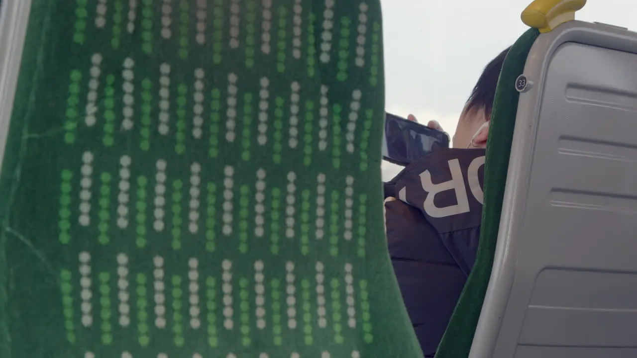 Passenger watching tv on phone on a train