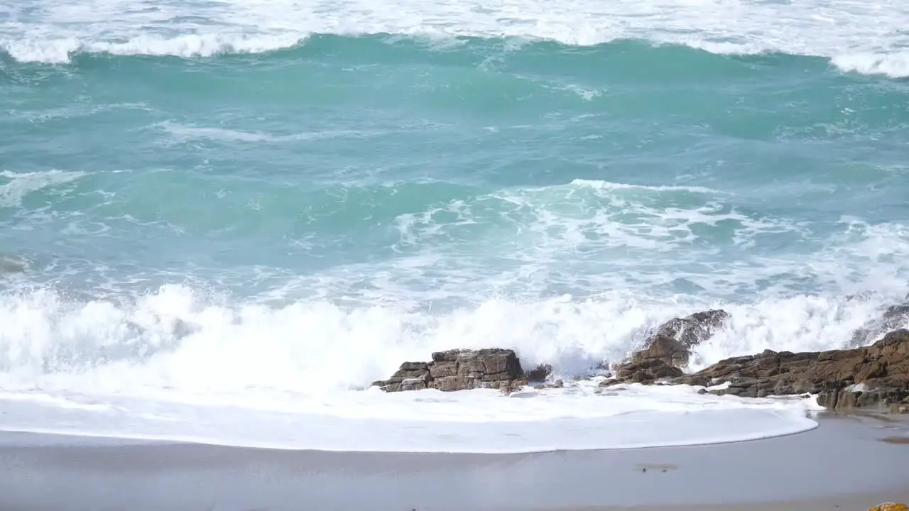 The waves in the sea crash into the rocks at the beach