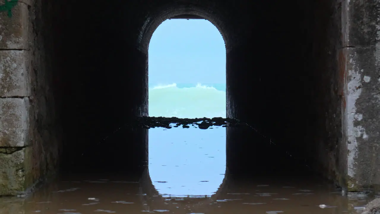 tunnel leads way to a wild sea where crashing waves rush in and create a rippling effect