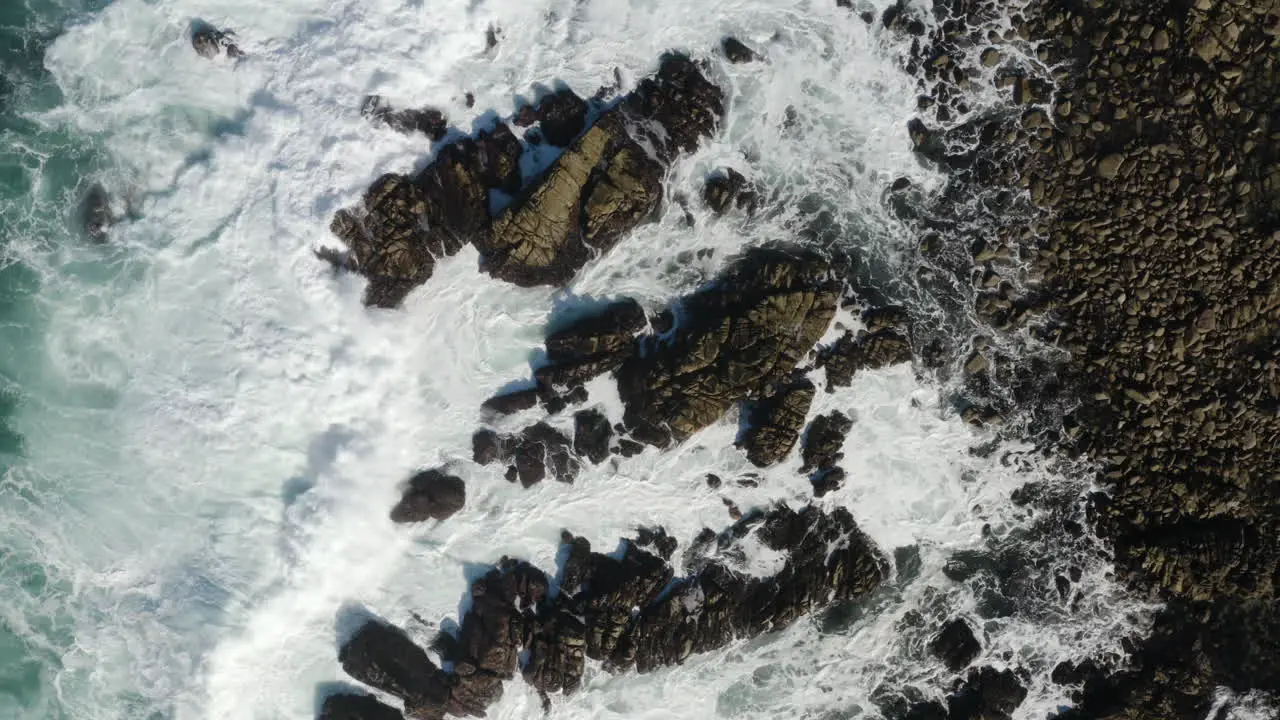 4K overhead drone shot of enormous wave smashing rocks on the California Coast