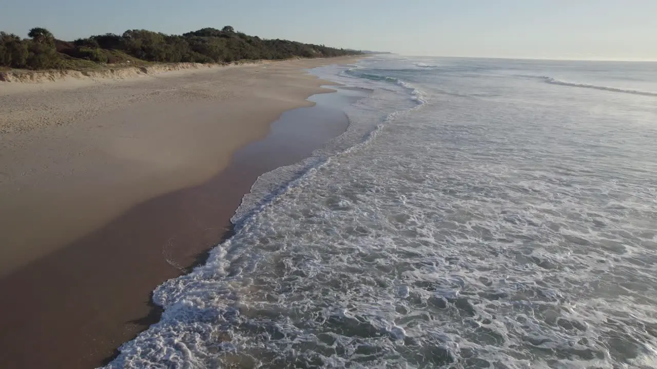 Foamy Waves Splashing Sandy Shore Of Coolum Beach In Sunshine Coast Region Queensland Australia aerial drone shot