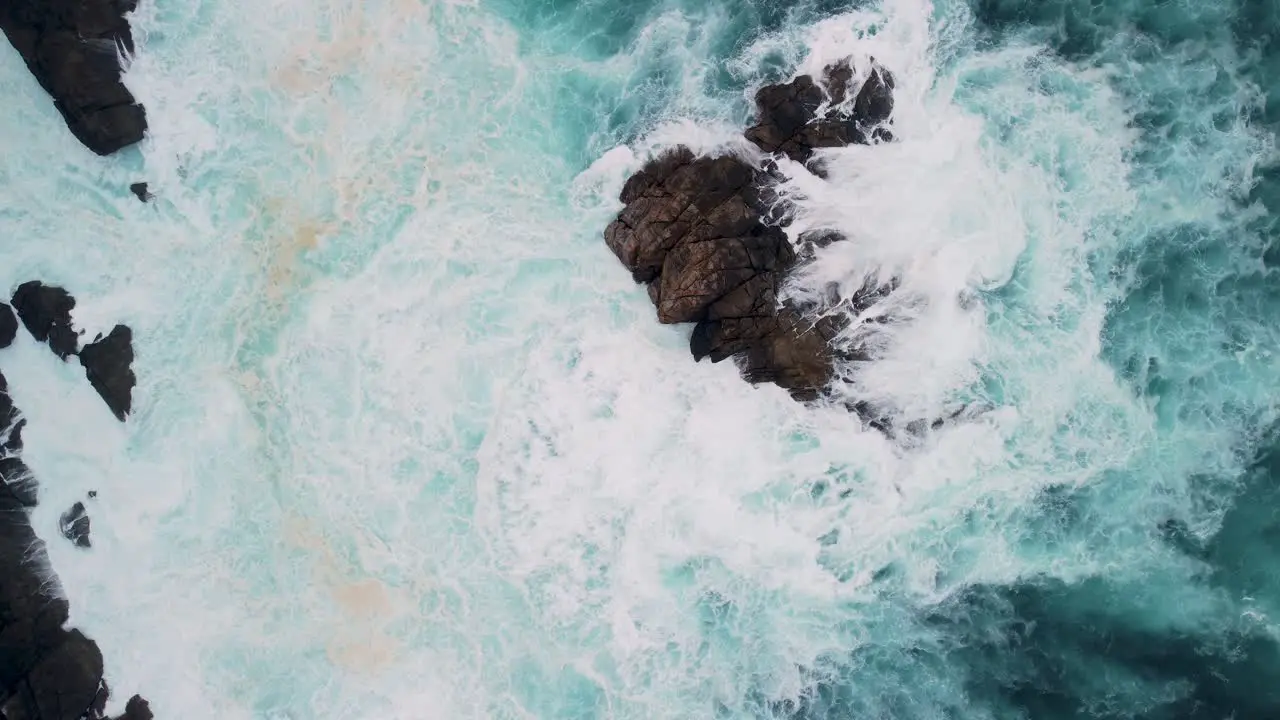 Overhead View Of Foamy Waves Breaking On Outcrops In Caion Beach Coruna Spain