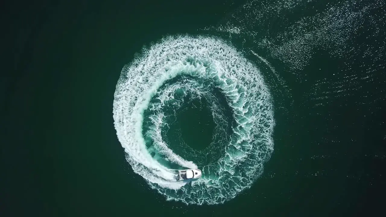 Aerial bird view of a speedboat riding in a circle and making beautiful round path in the sea