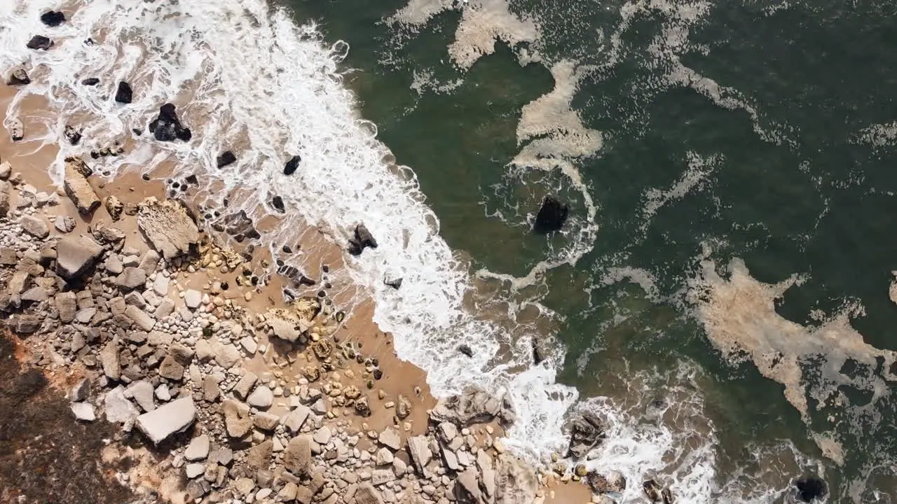 Sea waves crash along the rocky shoreline of Nazare Portugal a destination where the formidable force of the ocean converges with the varied expanse of rocky shores