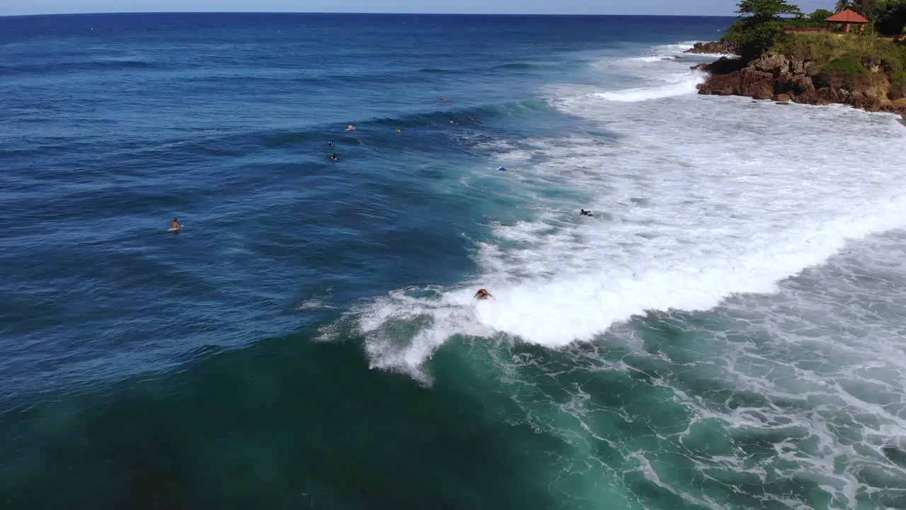 Surfer rides a wave crashing in the ocean in Rincon Puerto Rico during a clear day with blue sky