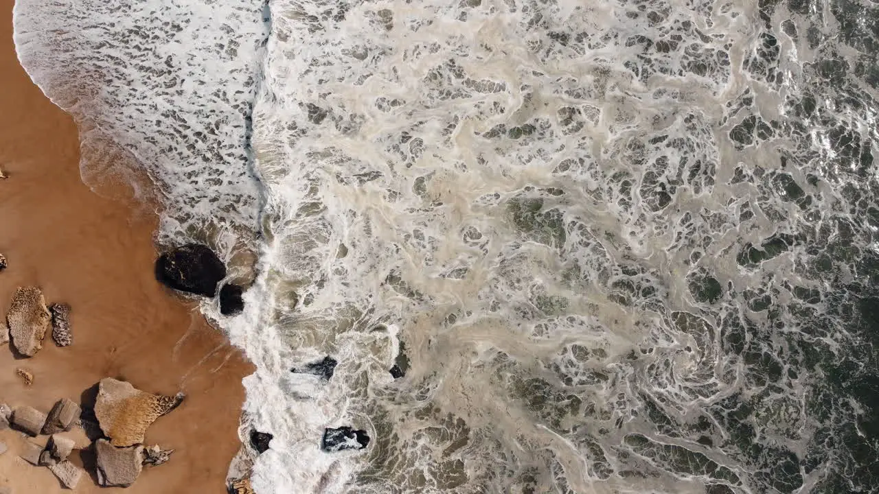 Sea waves crash against the rocky shoreline in Nazare Portugal a destination where the might of the ocean converges with the diverse expanse of rocky shores