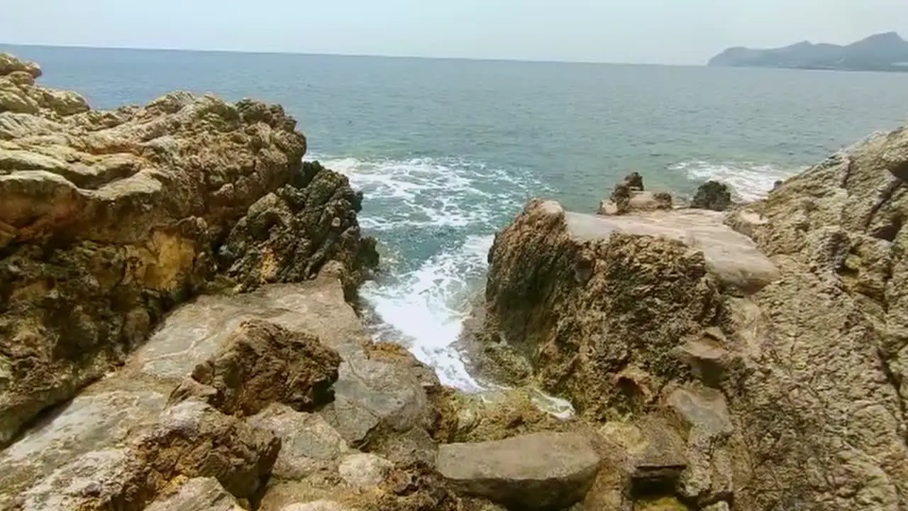 Sea waves flow and beat into the exciting rock structures of Cala Ratjada on Mallorca