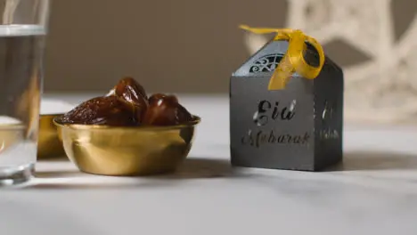 Bowl Of Dates With Sugar And Glass Of Water Celebrating Muslim Festival Of Eid With Gift Box And Symbol Of Pakistan