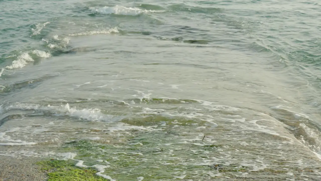 Slowmotion close up of waves hitting a pier or dock leading into the ocean sea