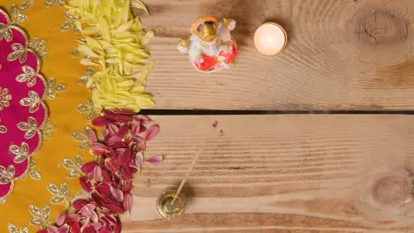 Overhead Of Table Decorated With Statue Of Ganesh And Incense For Celebrating Festival Of Diwali