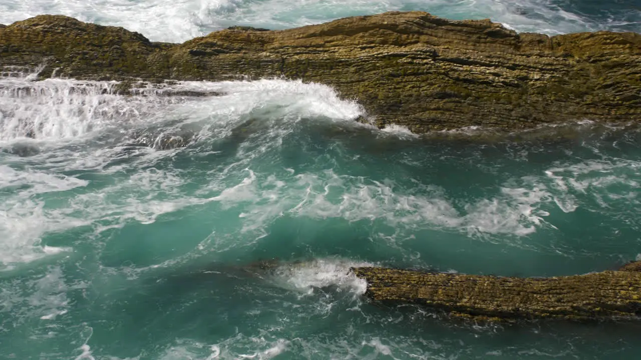 Waves crashing through sea rocks approaching shore